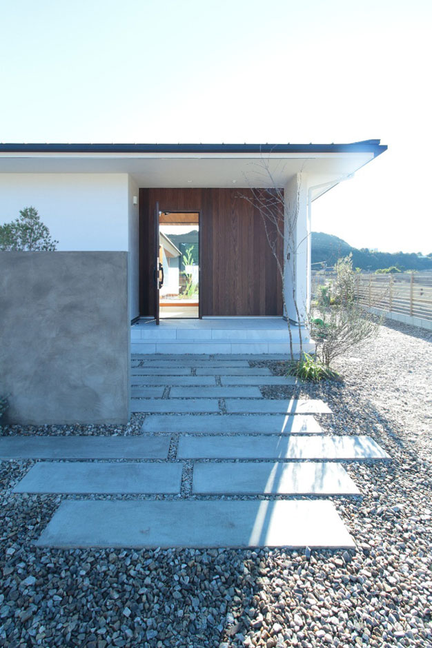 アイジースタイルハウス【デザイン住宅、建築家、平屋】深い軒の玄関。目隠しと玄関アプローチにコンクリートを使い、シンプルでもモダンなデザインに仕上げている