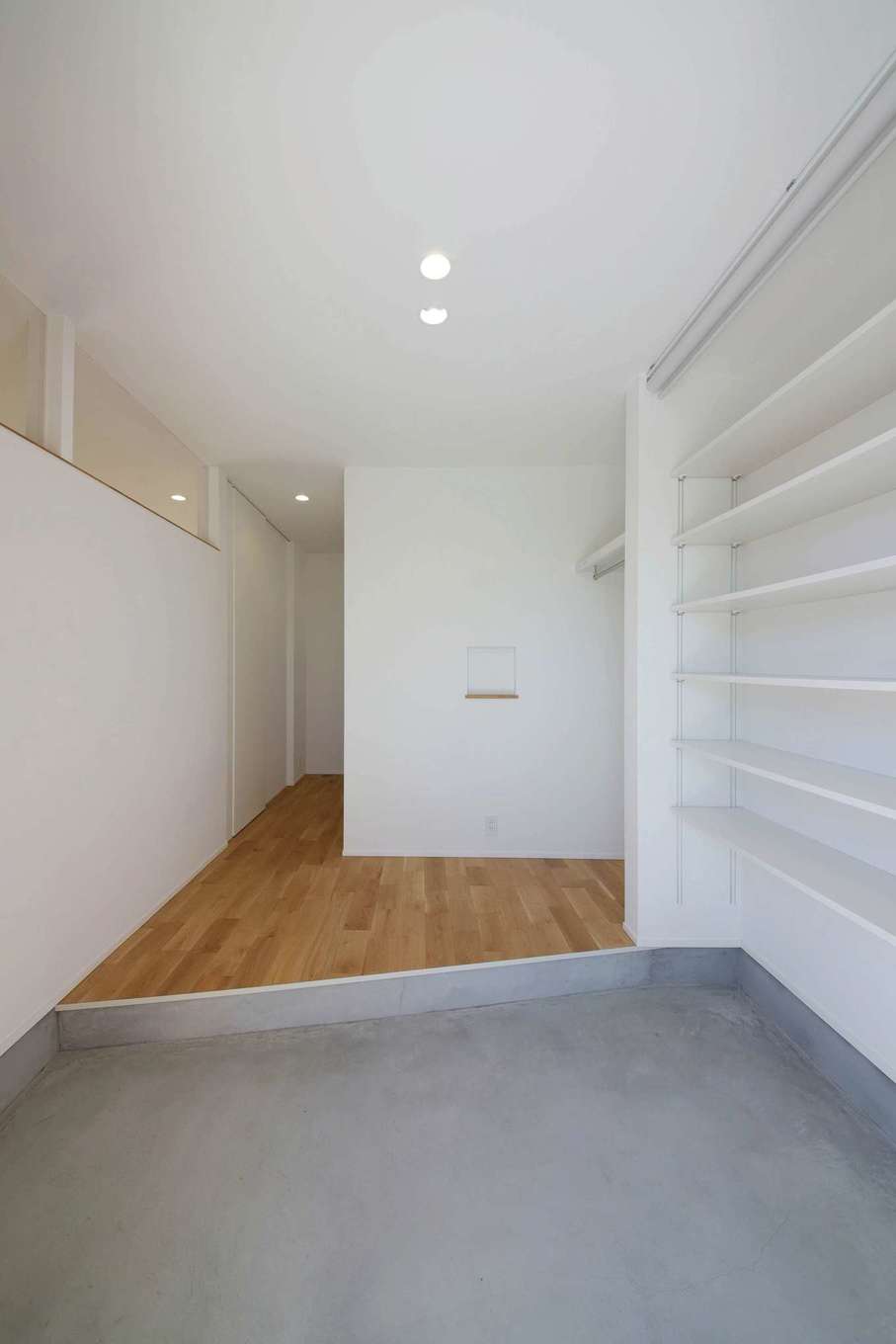 ひだまり工房【デザイン住宅、間取り、平屋】ドアを開けた瞬間、視線が奥へと抜けていくエントランス。上がり框を斜めにしているため空間に広がりが感じられる。リビングとの間仕切り壁の一部を透明ガラスにすることにより、十分な明るさを確保した。収納力も高く、お出かけ時の混雑も解消できる