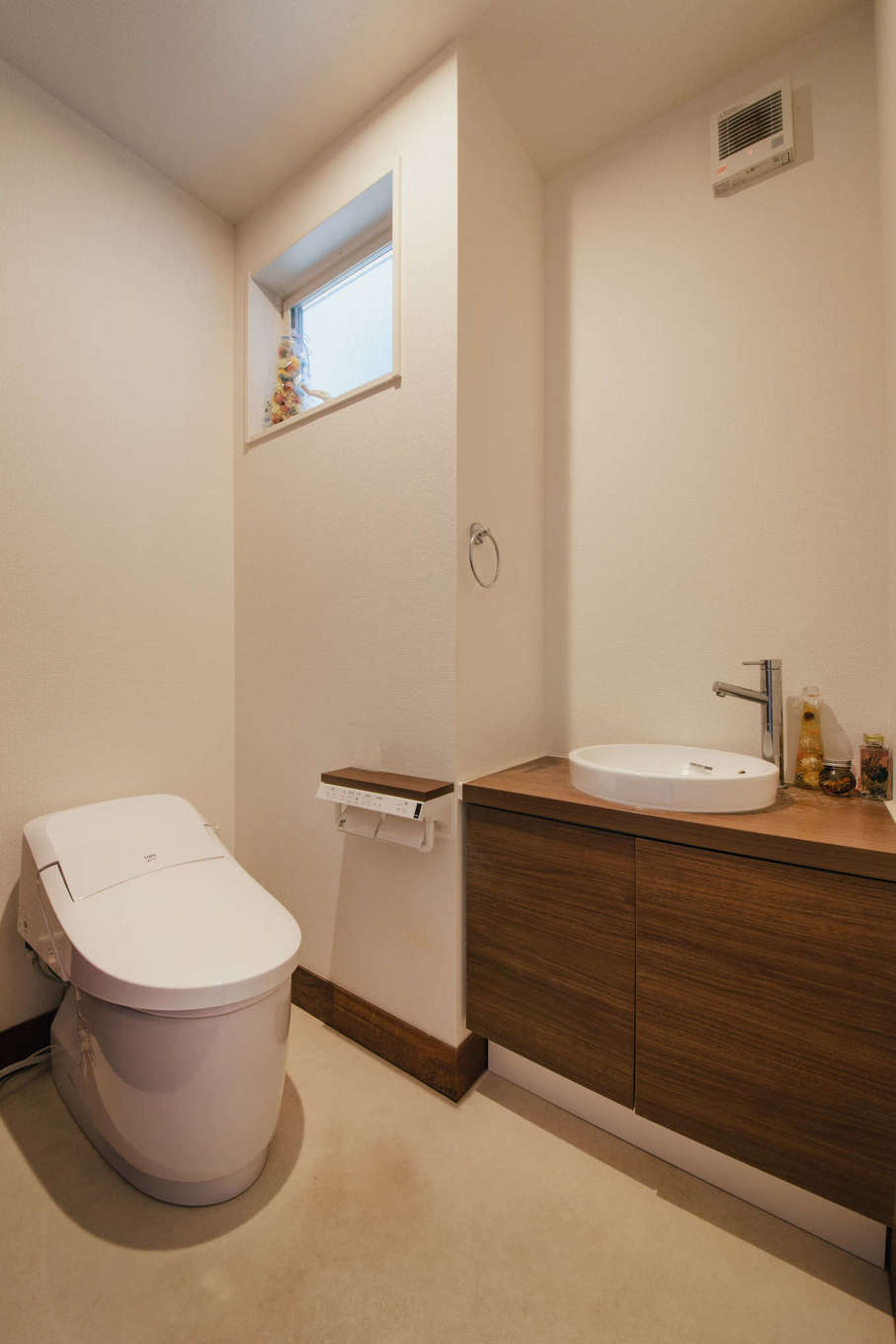 エフエフ住宅【子育て、和風、自然素材】トイレは手洗いカウンター付きで、室内の雰囲気に合わせて濃い木目を採用し、落ち着いた雰囲気に演出