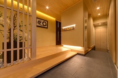 照明が演出する落ち着いた玄関ホールは和のテイストを採用。木素材と石材が絶妙にマッチし、訪れる人をやさしく迎える。