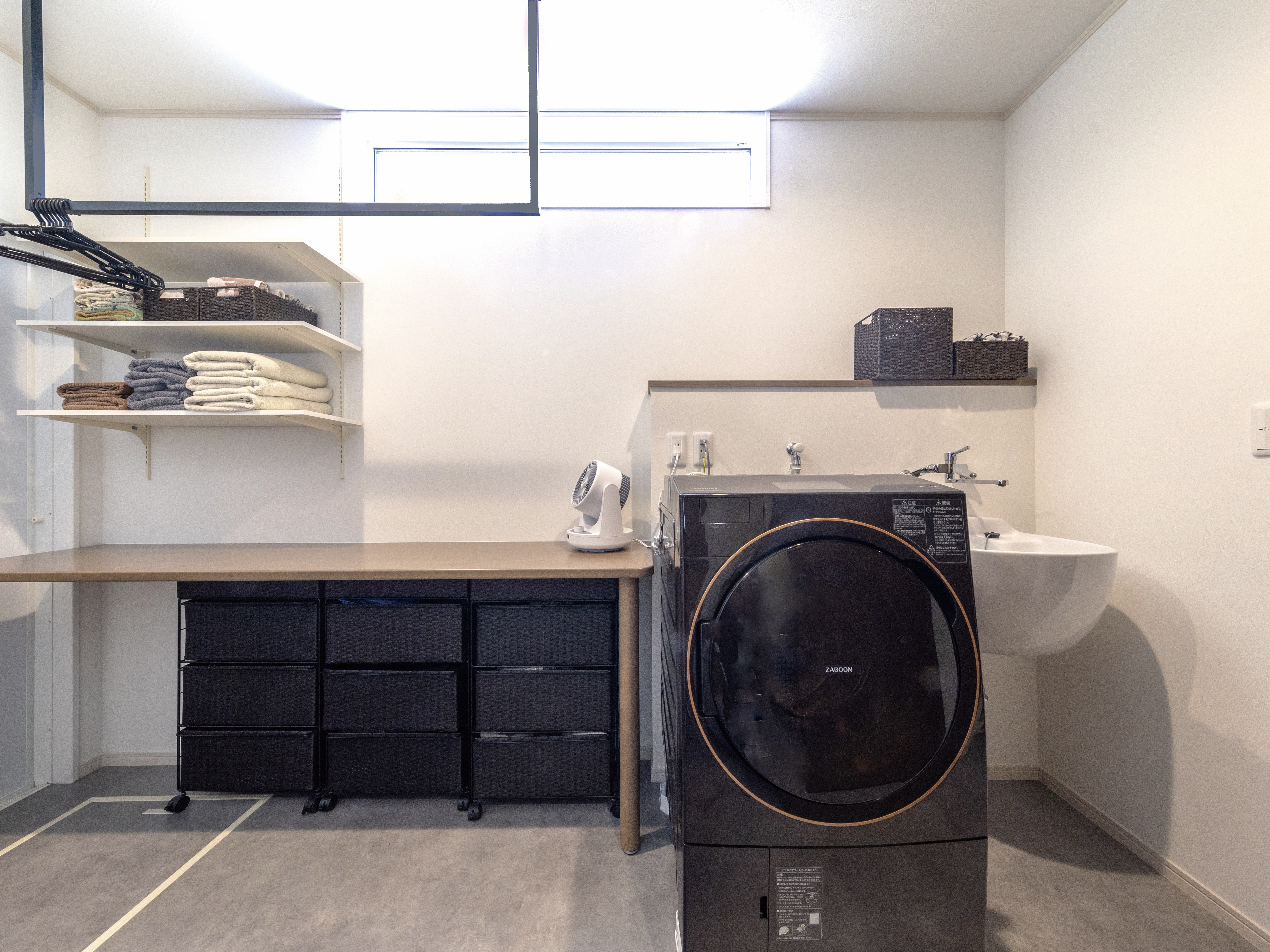 エスホーム｜機能的なランドリールーム。洗濯機や収納棚が効率よく配置され、洗濯作業をスムーズに行えるよう工夫されている。
