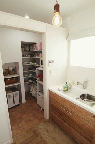 キッチンの横に広いパントリーをつくり、冷蔵庫、電子レンジなどの家電、食器、食料のストック品を置いています。パントリー内の棚は、持っているもののサイズを全て図り、自分たちで位置や幅、奥行き、コンセントやゴミ箱を置く位置も考えて、オリジナルで造作