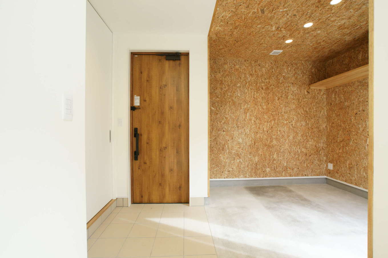 RIKYU 一級建築士事務所【趣味、間取り、建築家】ご主人が趣味を楽しむための広い土間玄関スペース。OSB合板を貼って男前な雰囲気を演出した