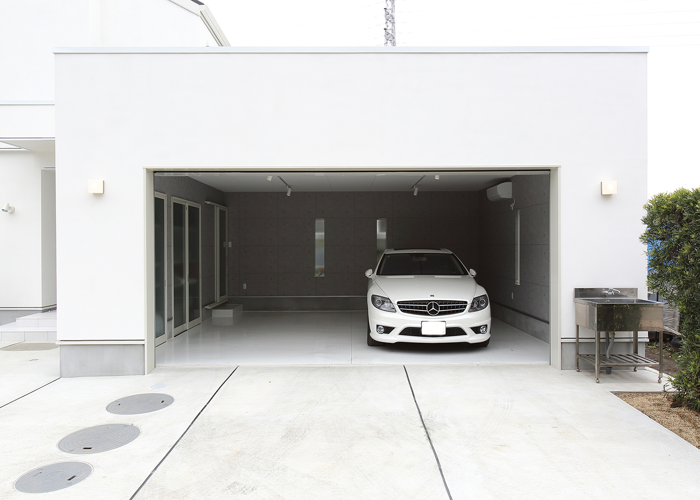 丸昇彦坂建設【デザイン住宅、間取り、ガレージ】二台の車が余裕をもって駐車できるガレージ。散水栓を設置し車の清掃にも便利