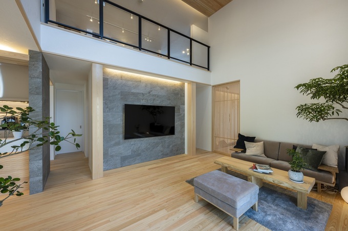 高い天井と大きな窓が開放感を演出する明るいリビング。シンプルなインテリアが空間を広く見せ、モダンなテイストを感じさせる。