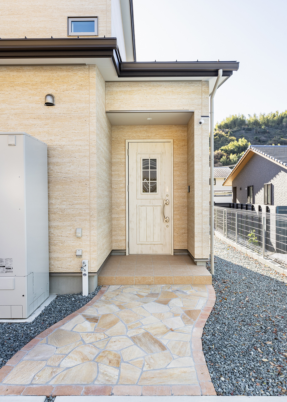 シバタ建設【デザイン住宅、省エネ、間取り】駐車場から玄関ポーチへは石畳のアプローチを。奥さまの希望で採用した外壁は、小さな穴が特徴の大理石「トラバーチン」模様のサイディング
