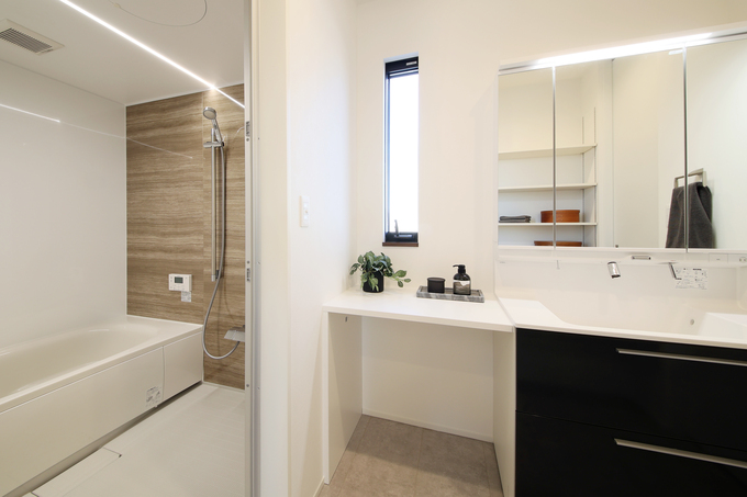 モダンで機能的な洗面スペース。シンプルなデザインと広々としたカウンターが特徴で、洗面や身支度がしやすい環境を提供。リラックスムードのバスルームと直結した配置。