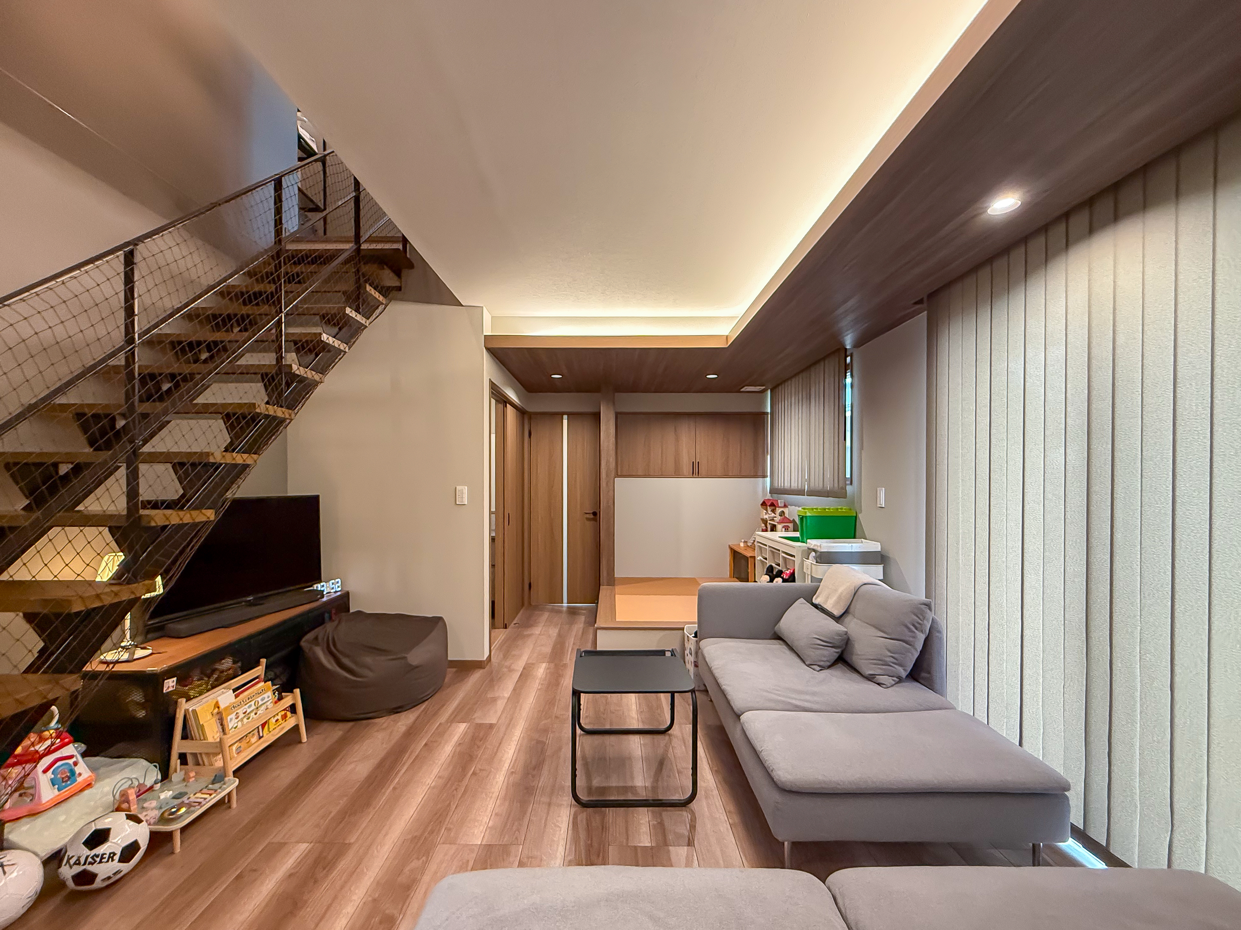 ロイヤルウッド｜モダンで落ち着いた雰囲気のリビングルーム。開放感のあるスケルトン階段が特徴で、自然光が差し込む明るい空間。