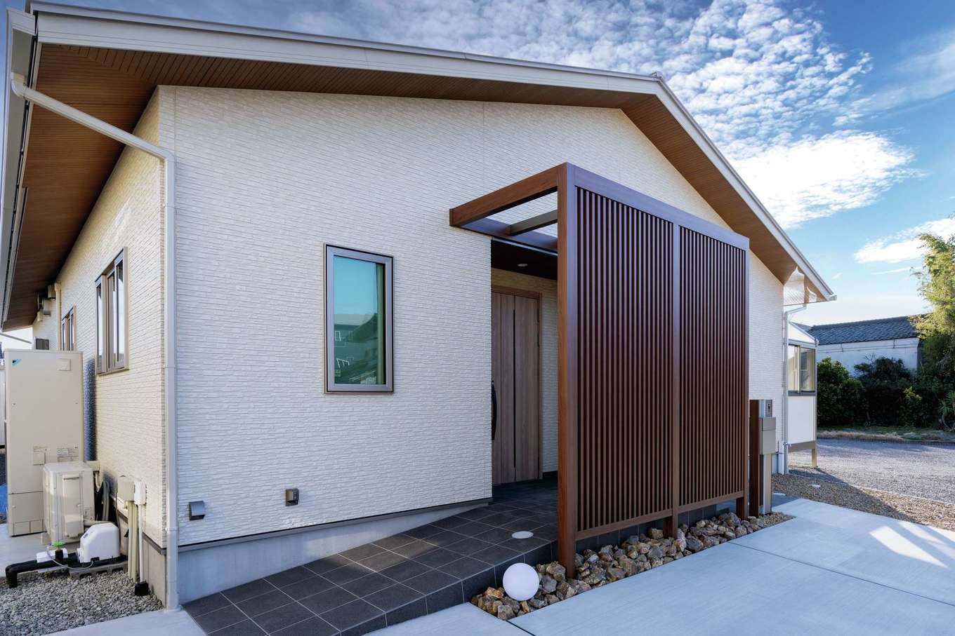 寺田工務店【省エネ、間取り、平屋】将来の暮らしに備えて、アプローチにスロープをつけた。ファサードに格子塀を設けたことで、玄関が丸見えにならず、プライバシーを確保できる