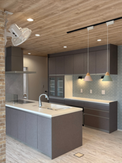 グレージュで統一されたモダンなキッチンスペース。広々としたワークトップとおしゃれなペンダントライトが特徴です。