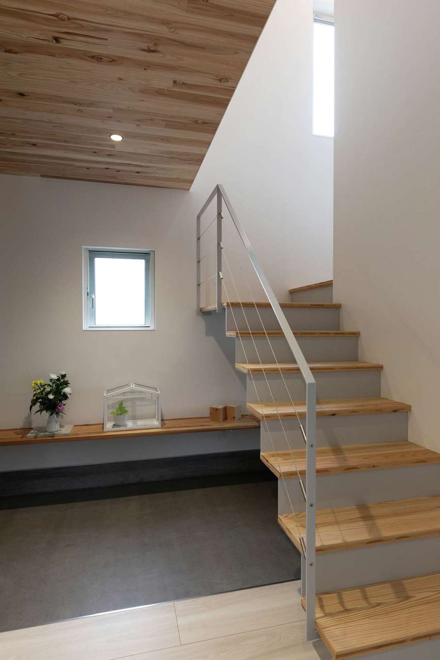 建杜 KENT（大栄工業）【デザイン住宅、収納力、間取り】玄関ホールからリビングを抜けて2階へと上がる、ユニークな配置の階段。デザイン的な空間のアクセントと、帰宅した家族が必ずリビングを通るという安心感を満たす