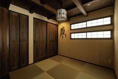 和室は建具を閉めれば個室に。収納内部には調湿効果に優れるスギを採用。奥さまセレクトの平和結びのしめ縄が照明に浮かぶ