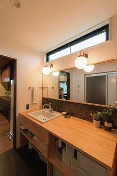 念願の造作洗面台。鏡も大きく、身支度しやすい。右手に乾燥機があり、広いカウンターは畳むのに重宝