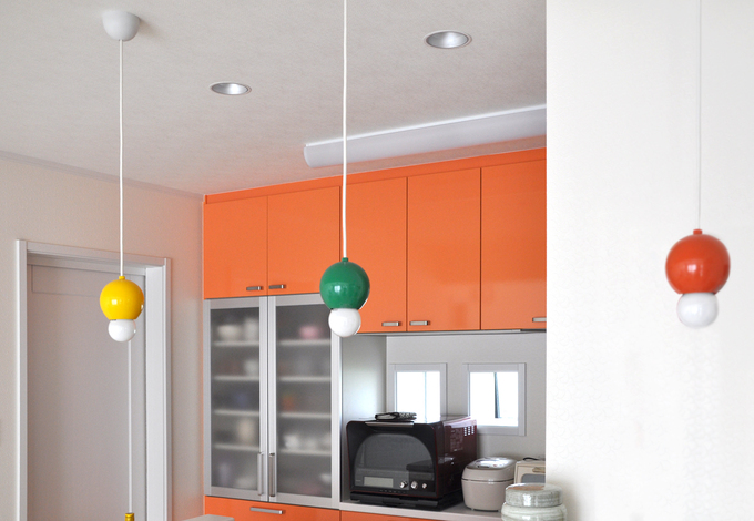 奥さまこだわりのオレンジのカップボードと流しで明るいキッチン。リビングへの距離も短く、家の中心に配置した。どこからでもママがそばにいる