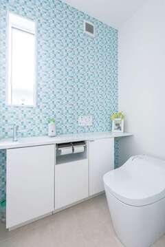 コンパクトながら収納力のあるトイレカウンター。明るいカラーのクロスで清潔感のある空間に