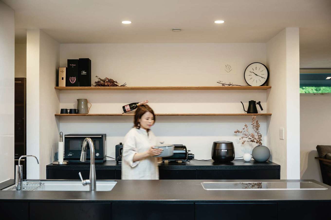 ainoa.life くらはし建築【デザイン住宅、間取り、インテリア】ストック食品やキッチン用品など、生活感のあるものはすべてパントリーに隠した、スタイリッシュなキッチン。背面の木の棚には、奥さまのお気に入りの雑貨や季節の花などを飾って愉しむ毎日。好きなものに囲まれた空間で、料理のテンションも上がる