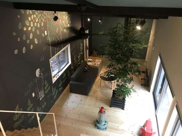 ロフトからリビングを見下ろす。勾配天井により、平屋でも圧迫感がなく、大勢の仲間を迎えても快適に過ごせる。床に採用した無垢のパイン材は、時を経て、少しずつ高級なハチミツ色に変わっていく