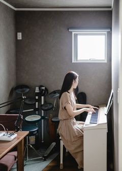 ピアノやドラムセット、ギターなどが並び、音楽を楽しむ趣味部屋。シックなクロスでコーディネートして、落ち着いた印象に
