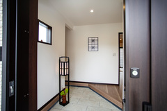 深岩石のタイルを敷き詰めた味わいある玄関。