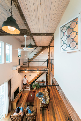 富士ホームズデザイン｜開放感あふれる吹き抜けのLDKは、窓の向こうに駿河湾を望む夫妻お気に入りの場所。オリジナル仕上げの床やラフに塗った天井のスギ板が味わいを添える