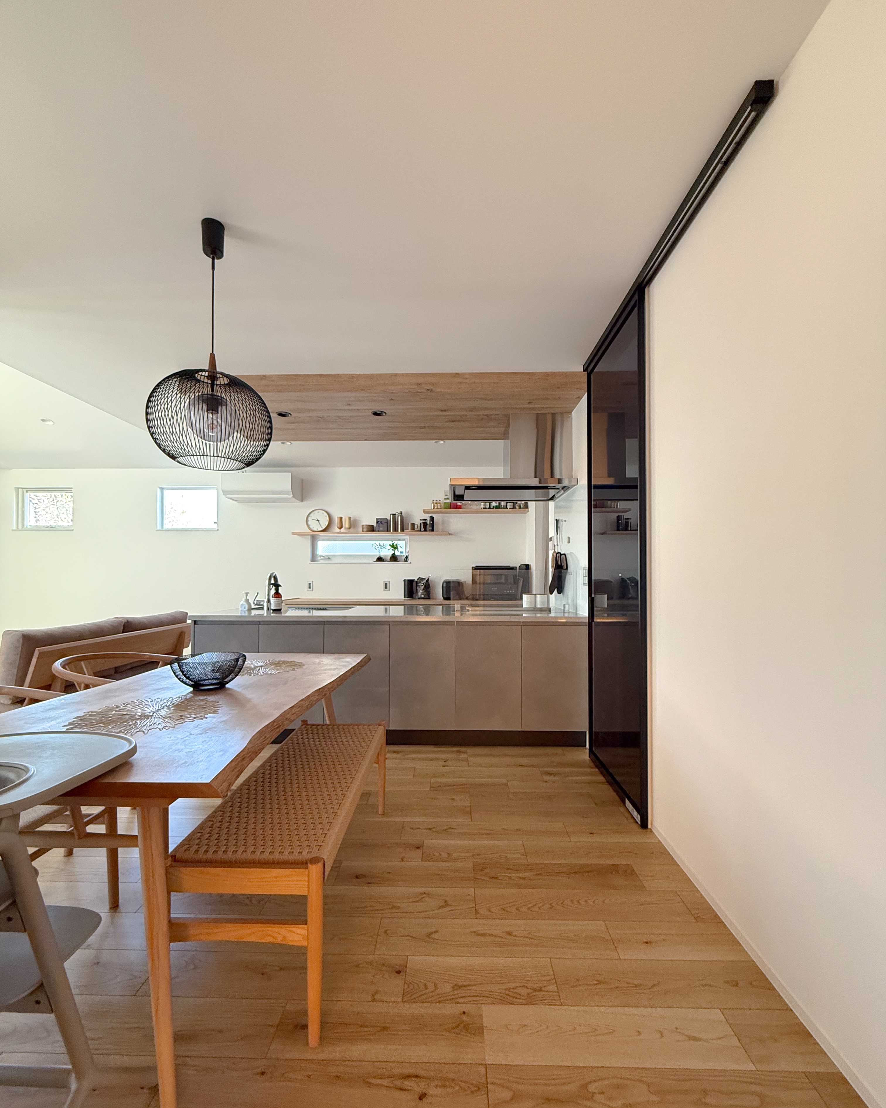 ロイヤルウッド｜木の温もりを感じるリビングダイニング。シンプルながらも洗練されたデザインで、照明がアクセントとなり落ち着いた空間を演出している。