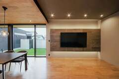 ダイニングとリビングの天井高を20cm変えたことで、空間にメリハリが生まれた。浮かび上がるようなテレビボードは調湿性にすぐれたエコカラットを採用し、高級感を出した