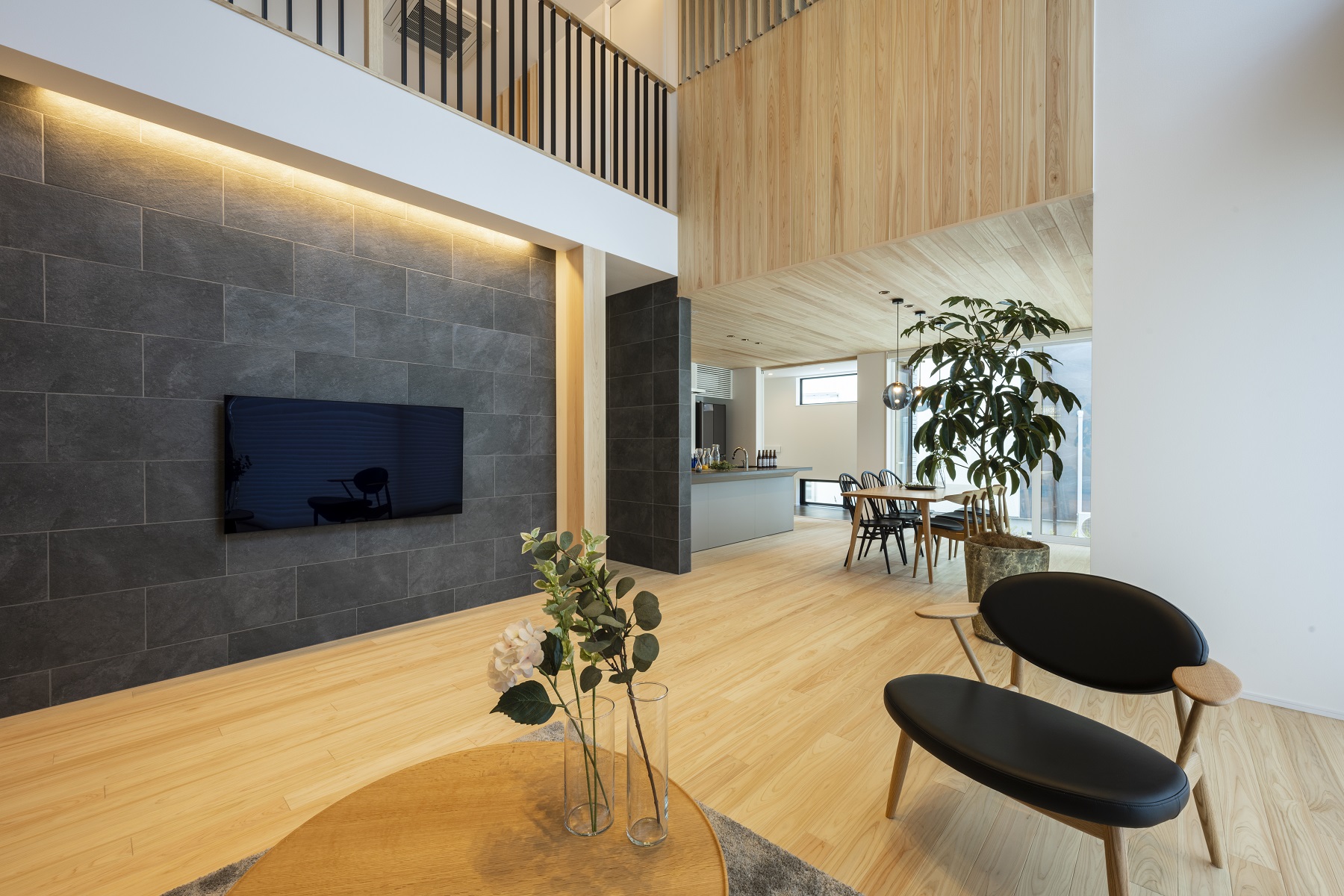 日本ハウスホールディングス 岐阜｜開放的なLDKで、吹き抜け天井とシンプルなデザインが特徴。自然光がたっぷり入り、家族がくつろげる空間を演出している。