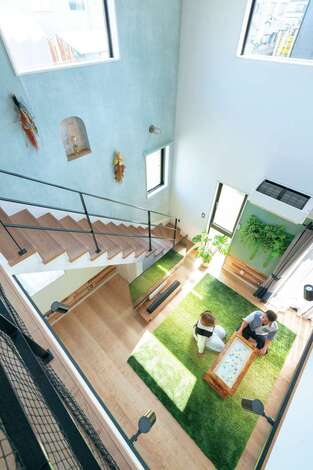 階段の壁にはアーチ型のニッチを。奥さまのお母さまが手づくりするリースやブーケが空間を彩っている。大きな窓は室内に明るい光を取り込むとともに、抜群の開放感をもたらす