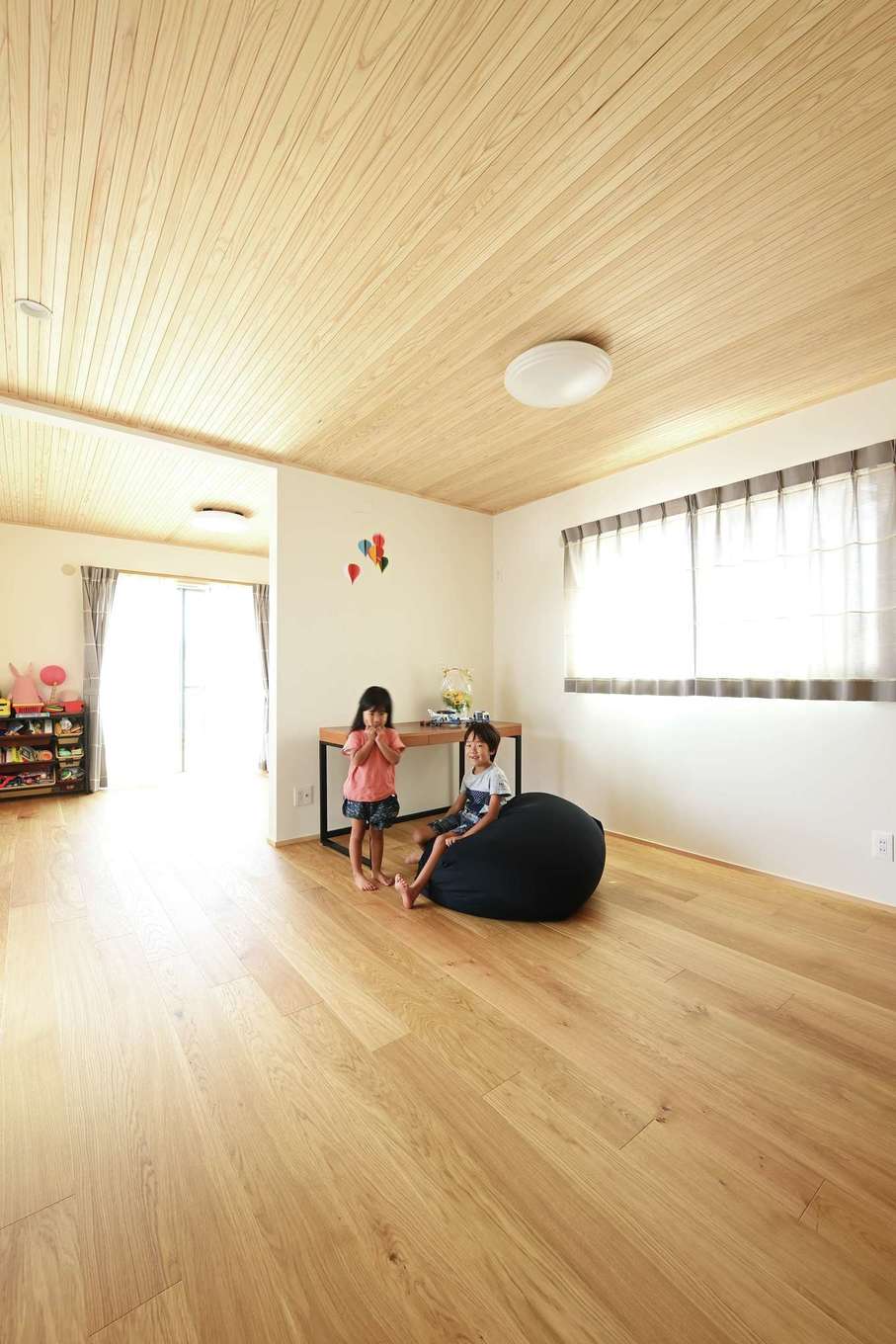 Yamaguchi Design 【自然素材、間取り、スキップフロア】1階の子ども部屋は14畳で、将来的に仕切ることも可能。子どもが巣立ったら夫妻の寝室にして平屋風に暮らすこともでき、可変性の高い秀逸な間取り
