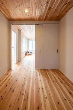 リビングとバリアフリーでつながる寝室。建具には左右どちらにも開閉できる吊り戸を採用。足元にレールがないのでつまずきの心配もなし