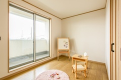 押し入れの収納が便利な居室。バルコニーへつながる大きな窓があり、開放感が感じられるスペースである。