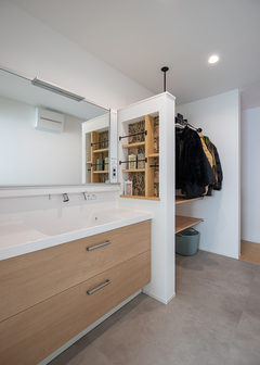 洗面化粧台の横に設けたニッチ収納は、普段使いの生活必需品が収まる便利な場所。ここにもモリスの壁紙を貼って華やかに仕上げた