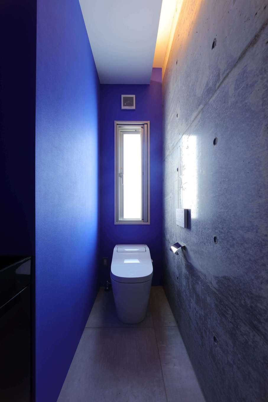 BAUM HOME（岩崎工務店）【デザイン住宅、平屋、鉄骨鉄筋コンクリート構造】トイレはブルーのアクセントカラーがポイント。間接照明を効果的に配置し、建築が主役のコーディネートでまとめた