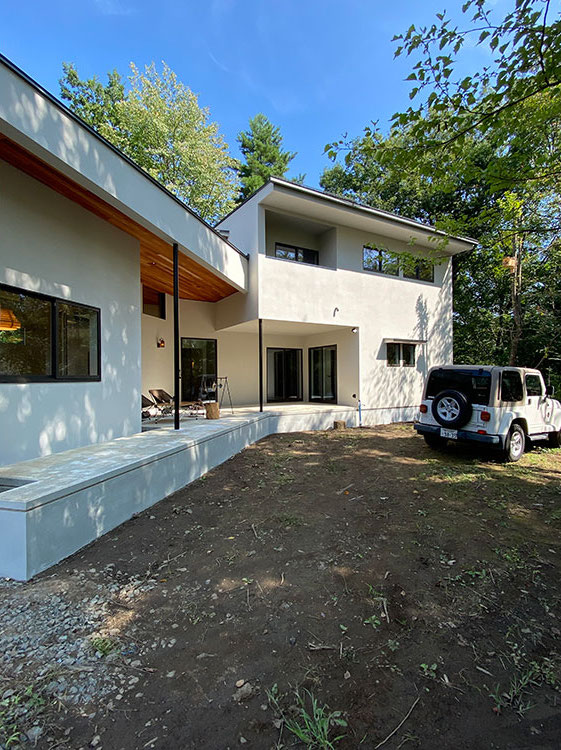 Techno Home Aizawa【デザイン住宅、自然素材、高級住宅】LDK・水回り・主寝室は1階に集約し、2階に子ども部屋を配置した半分平屋のような造り。豊かな緑に爽やかに映える白い外壁を、ブラックの直線が引き締める