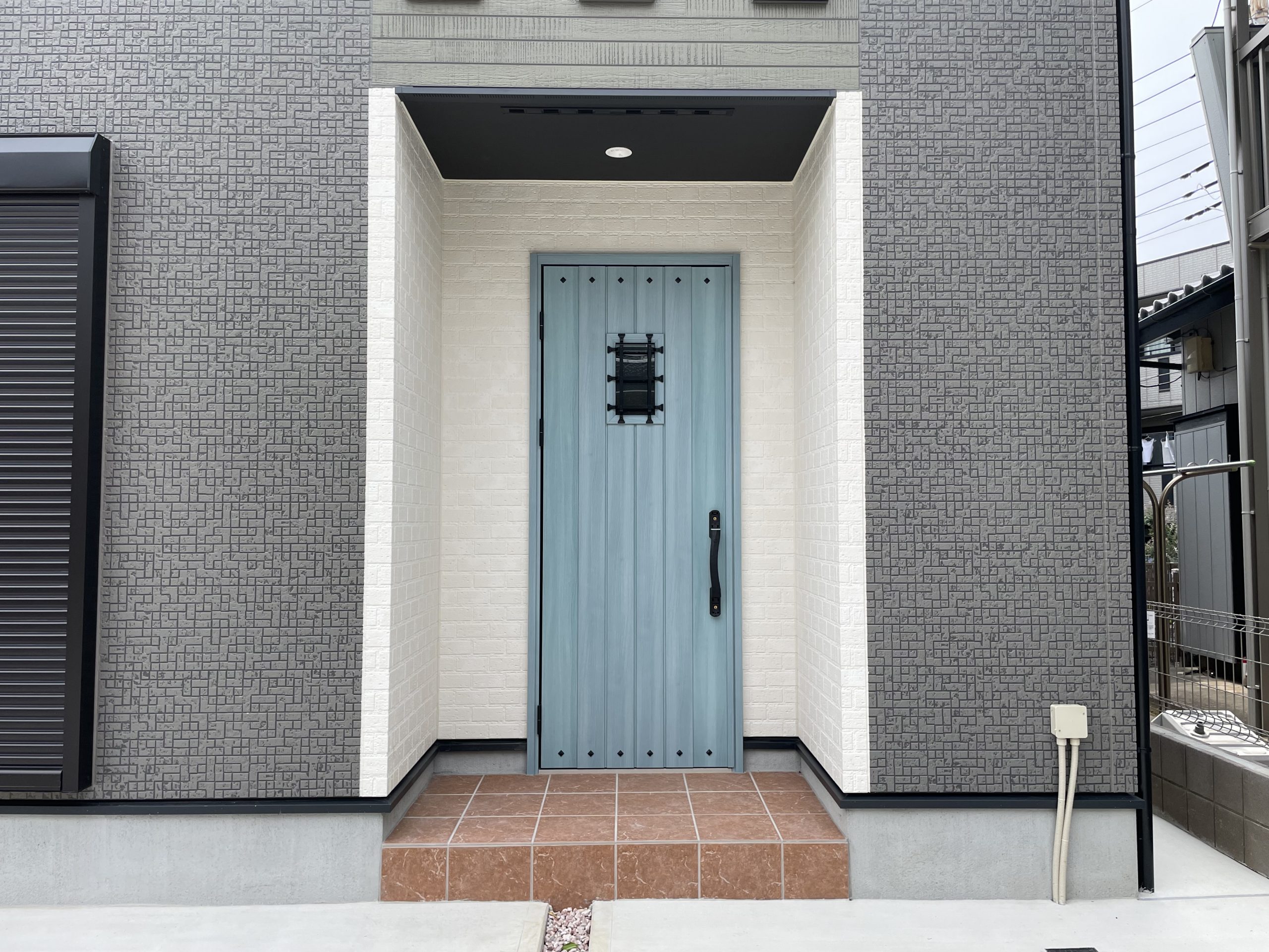 タムラ建築設計｜青いドアが印象的な、シンプルでモダンな玄関の外観。機能的なデザインで、訪れる人に落ち着いた雰囲気を提供する。