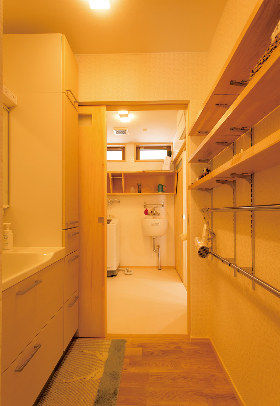 深見工務店 S-style【収納力、自然素材、間取り】キッチンと浴室、廊下をつなぐように、洗面室が2つ並んであるのが特徴的。洗濯機が置かれた一方の洗面室には、深さのある洗面ボウルを設置。ご主人の仕事着を手洗いするのに便利