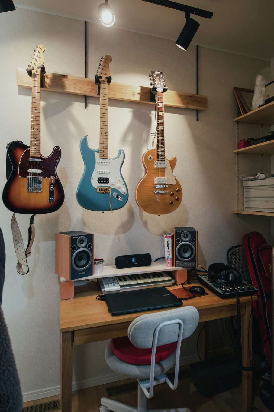 子育て安心住宅 Design Craft Office【デザイン住宅、子育て、間取り】音楽を通じて出会い、バンド活動を続けているお二人。階段下を含む3.5畳の空間には楽器が保管され、ワークスペースも取られている。こもり過ぎない環境なので、状況に応じての作業が可能。衣類なども掛けられ、LDKのキレイに貢献する