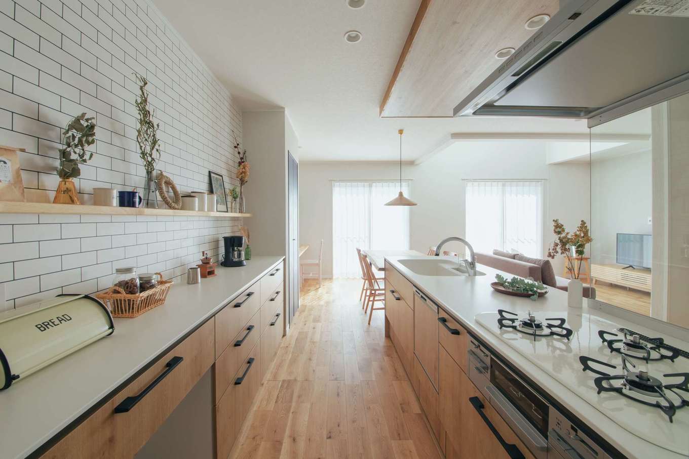 ほっと住まいる【自然素材、間取り、インテリア】キッチンとダイニングテーブルを横並びにしたことで、料理の配膳や片付けがしやすい。飾り棚を備えた背面収納も大容量