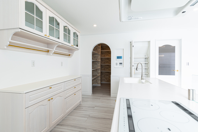 白を基調としたシンプルで洗練されたキッチン。大きな収納スペースと設備が整い、使いやすさに優れている。インテリアに調和するデザインが魅力的である。
