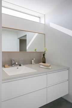 大人2人並んでも十分な広々とした洗面所。鏡上のスリット窓がより明るい空間にしてくれる。