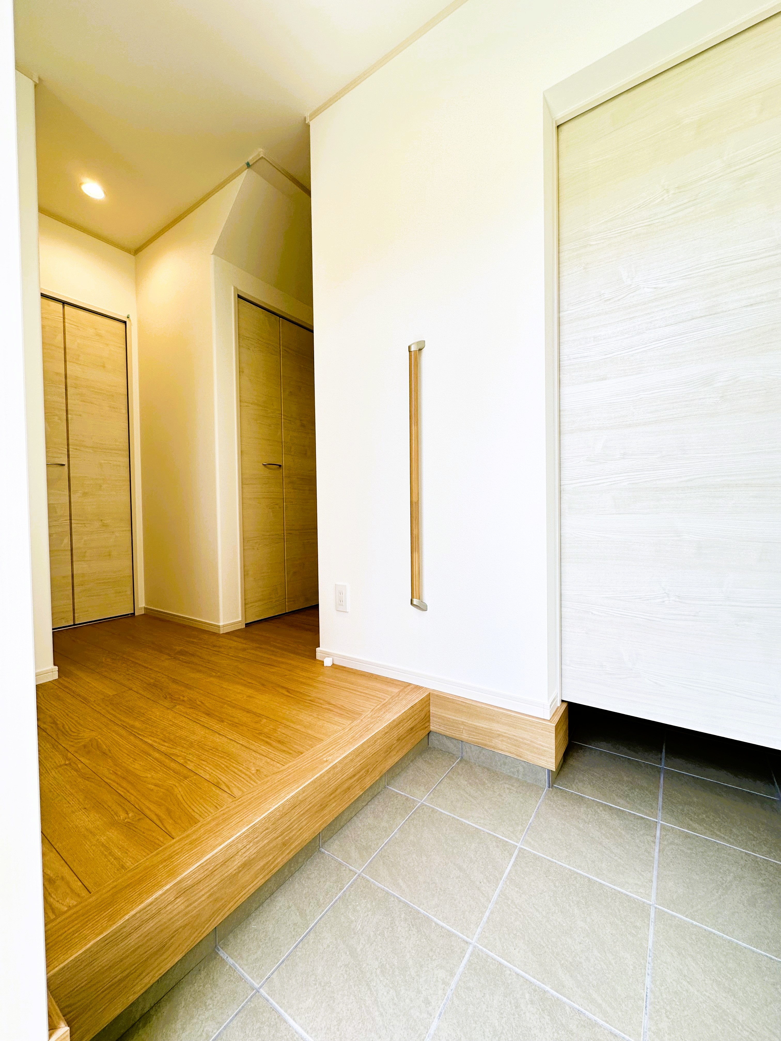 イシカワ 岐阜支店｜広々とした玄関ホールは、木目調の床と白壁が調和し、明るく開放的な印象。収納も完備されているので、機能的な空間である。