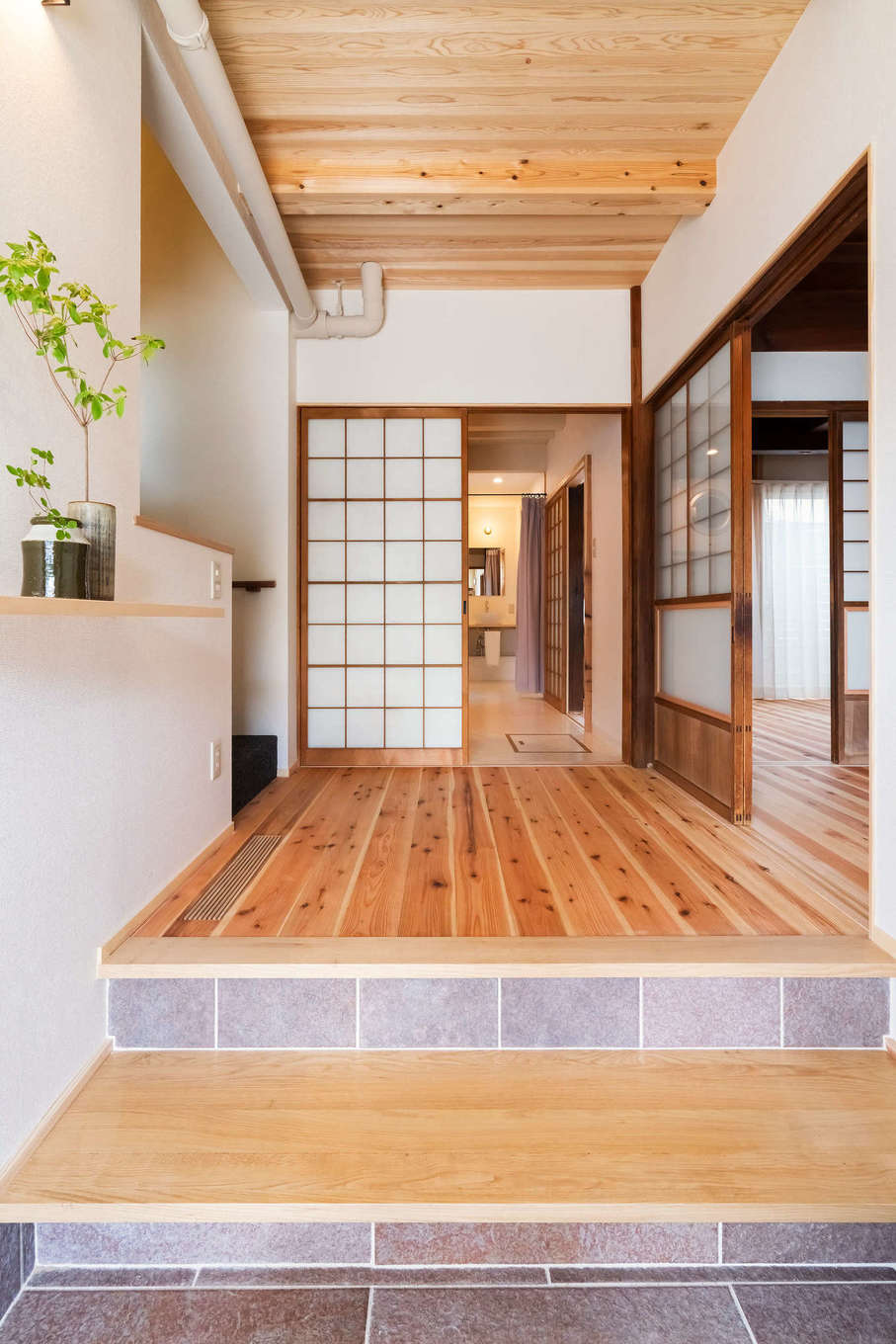 ALAIN（アラン）｜愛着のある改修した古い建具が味わいをもたらす玄関。スギ板張りを活かしつつ、床は新たに天竜杉をはめこんだ。玄関土間はタイル張りにし、懐かしさと新しさが程よく調和した空間が実現。１階にはお父さまの生活スペースと応接間が設けてある