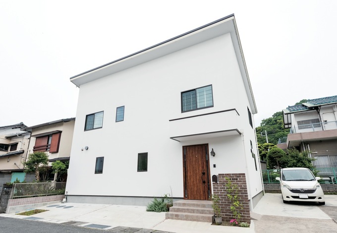 塗り壁の外観が静かな環境に溶け込む。太陽光発電の効率を考慮し、片流れの屋根を採用した