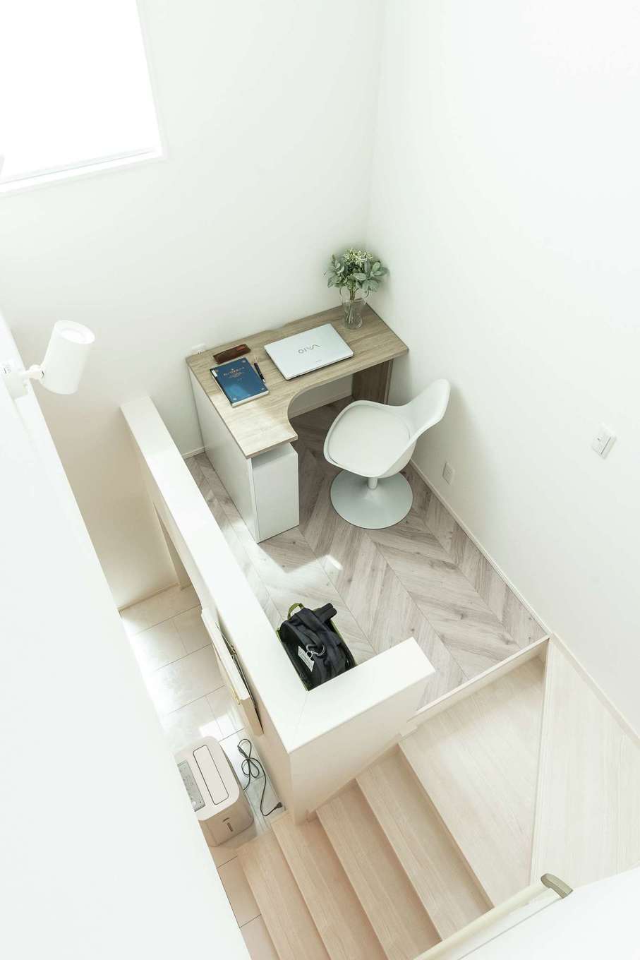 HAPPY HOUSE（山田工務店）【デザイン住宅、間取り、インテリア】吹き抜けは隣接する建物の高さや窓の位置を考慮して計画。プライバシーを守りつつ、たっぷりの明るさを招くよう間取りが整えられた。階段途中には書斎スペースを用意