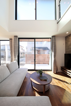 大きな窓からたっぷり光が差し込む開放的なリビング。シンプルなインテリアがモダンな雰囲気を引き立て、リラックスできる空間となっている。