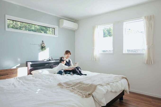 夫婦の寝室は水色のクロスを使い、さわやかな仕上がり。すぐ隣に機能的な収納ゾーンを用意。ウォークインにはアイロン掛けなどができる作業カウンターを依頼