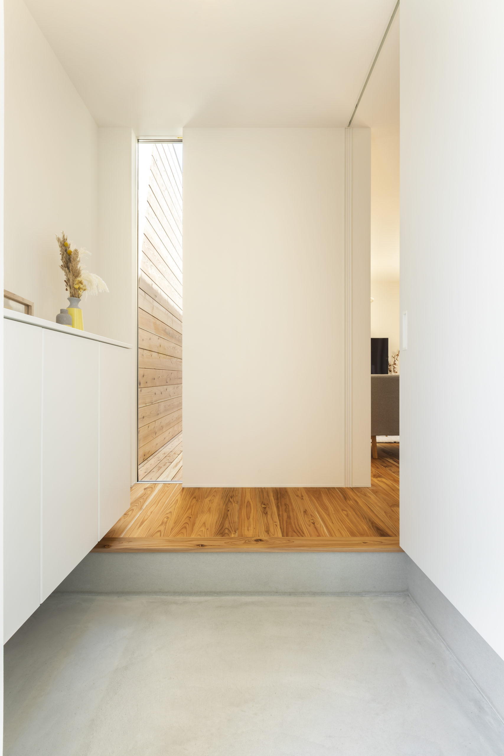 ETERNITY（エタニティ)　SIMPLE NOTE 浜松東【デザイン住宅、建築家、平屋】玄関ドアを開けると、FIX窓から光が注ぐ明るいホールが現れる。LDKの一部も見え、空間の広がりが感じられるつくりに