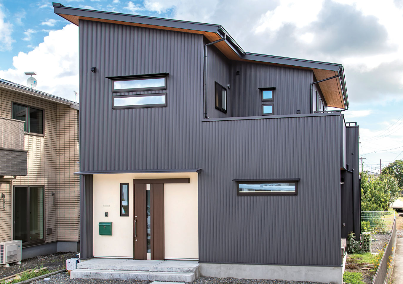 仲田工務店【デザイン住宅、子育て、間取り】シックな色味のガルバリウムで重厚な雰囲気の外観。木の軒天は同社の見学会で見て取り入れた