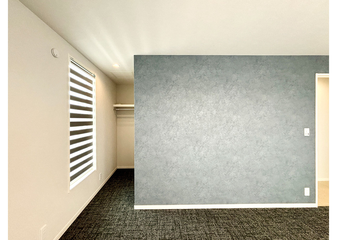 ミサワホーム静岡【デザイン住宅、収納力、間取り】ウォークインクローゼットのある主寝室。シックなグレーのアクセントクロスで、明るさと落ち着きを両立している