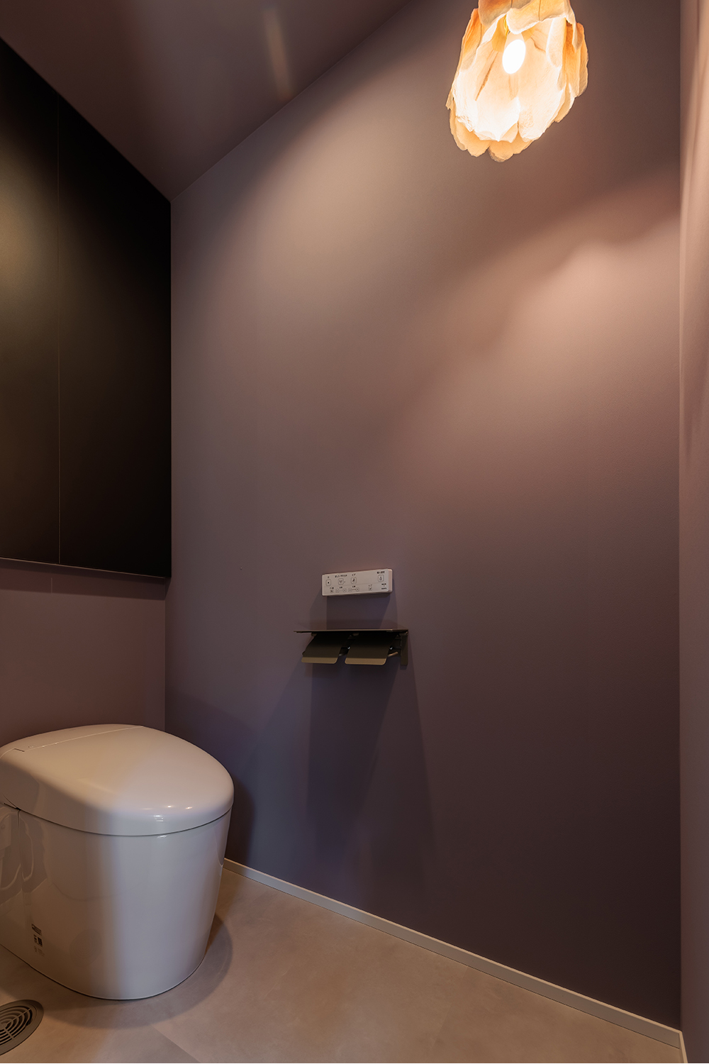 tact design firm【デザイン住宅、子育て、間取り】奥さまが大好きな作家さんによるお花のクラフト照明が特徴的なトイレ。シンプルながらも上品なデザインで、リラックスできる空間を提供している